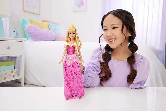 Mattel Disney Princess Aurora Doll in Sparkling Fashion with Removable Skirt InspirMattel Disney Princess Aurora Doll in Sparkling Fashion with Removable Skirted by the animated character in Disney's Sleeping Beauty, this Aurora doll is ready to make her dreams come true! The posable fashion doll wears her sparkling signature fashion inspired by the movie, including removable shoes and tiara. Her outfit includes a glitter bodice and removable skirt with a storytelling pattern unique to Aurora. This Disney Princess doll features long hair for endless styling and brushing fun! Kids will love to play out their favorite movie moments from Disney's Sleeping Beauty or make up their own stories! Fans can collect all the Disney Princess fashion dolls for the ultimate adventure! Each sold separately, subject to availability.